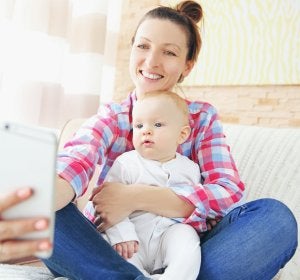 Una mujer haciéndose un selfie con su bebé Una mujer haciéndose un selfie con su bebé