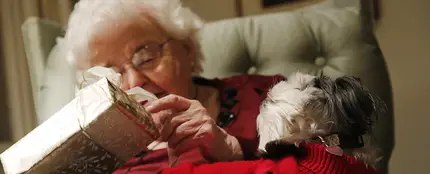 Abuela abriendo un regalo de Navidad Abuela abriendo un regalo de Navidad