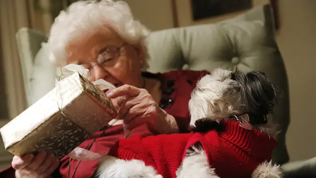Abuela abriendo un regalo de Navidad