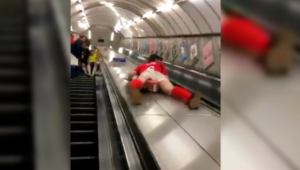 Un hombre se tira por las escaleras del metro como un tobogán