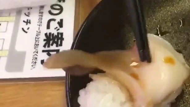 Un trozo de almeja en una pieza de sushi que se mueve Un trozo de almeja en una pieza de sushi que se mueve