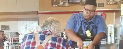 Evoni Williams ayudando a cortar el filete de este anciano Evoni Williams ayudando a cortar el filete de este anciano