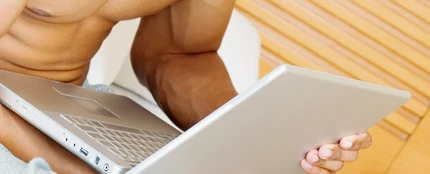 Un chico con el portátil en la cama Un chico con el portátil en la cama