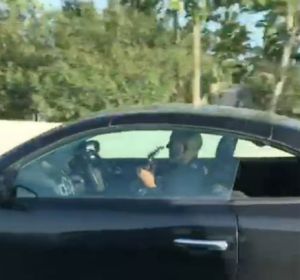 Un hombre tocando la guitarra mientras conduce sin sujetas el volante Un hombre tocando la guitarra mientras conduce sin sujetas el volante