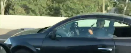 Un hombre tocando la guitarra mientras conduce sin sujetas el volante Un hombre tocando la guitarra mientras conduce sin sujetas el volante