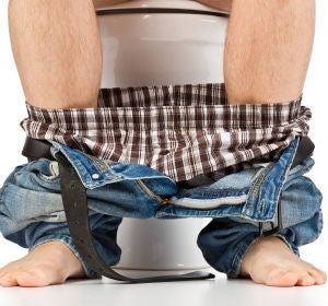 Hombre sentado en el WC Hombre sentado en el WC