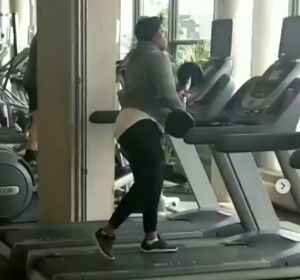 Una mujer golpeando una cinta de correr con unas pesas Una mujer golpeando una cinta de correr con unas pesas