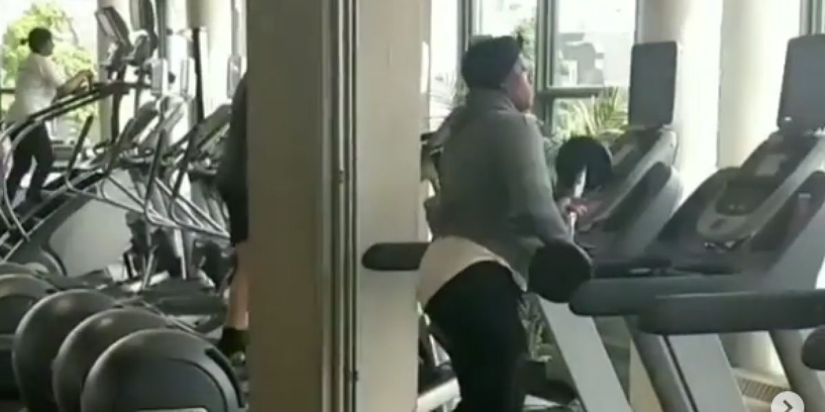 Una mujer golpeando una cinta de correr con unas pesas