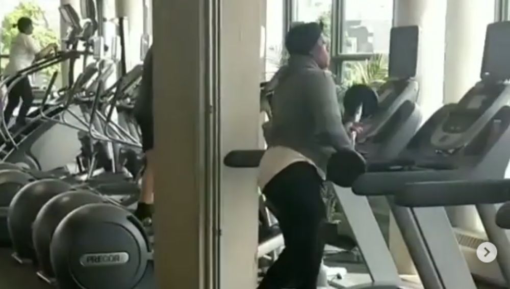 Una mujer golpeando una cinta de correr con unas pesas