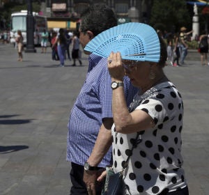 Señora tapándose con el abanico por el calor Señora tapándose con el abanico por el calor