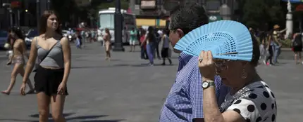 Imagen de archivo de una mujer tapándose con el abanico por el calor Imagen de archivo de una mujer tapándose con el abanico por el calor