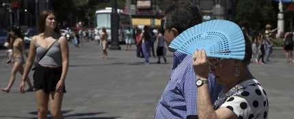 Imagen de archivo de una mujer tapándose con el abanico por el calor Imagen de archivo de una mujer tapándose con el abanico por el calor