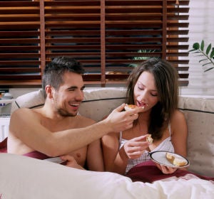 Una pareja desayunando en la cama Una pareja desayunando en la cama