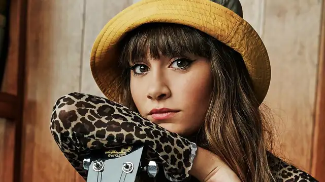 Aitana posando junto a una guitarra
