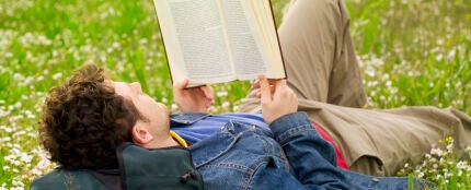 Un chico leyendo en un parque