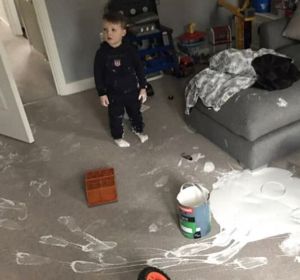 Un niño de tres años cubre su salón recién reformado de pintura blanca Un niño de tres años cubre su salón recién reformado de pintura blanca