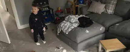 Un niño de tres años cubre su salón recién reformado de pintura blanca Un niño de tres años cubre su salón recién reformado de pintura blanca