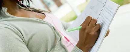 Mujer escribiendo en una libreta Mujer escribiendo en una libreta