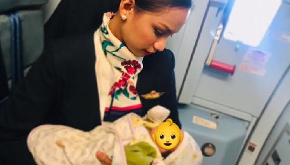 Una azafata de vuelo amamantando a un bebé