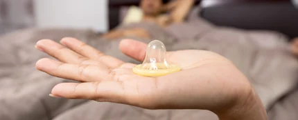 Una mujer con un preservativo en la mano Una mujer con un preservativo en la mano