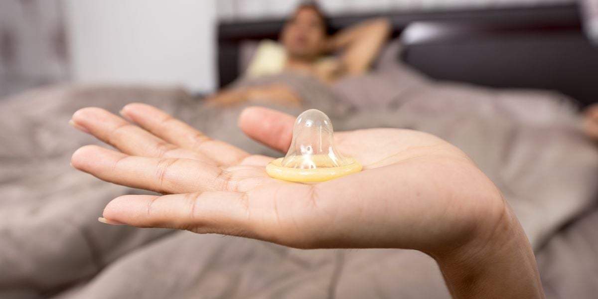 Una mujer con un preservativo en la mano