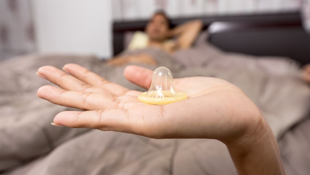 Una mujer con un preservativo en la mano