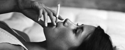 Chica fumando en la cama