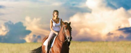 Una mujer montando a caballo