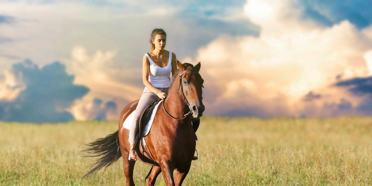 Una mujer montando a caballo