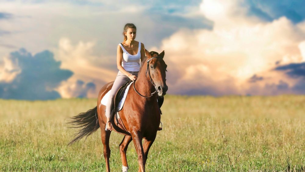 Una mujer montando a caballo