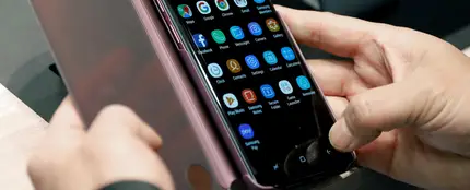 Una persona revisa la pantalla de un móvil Una persona revisa la pantalla de un móvil