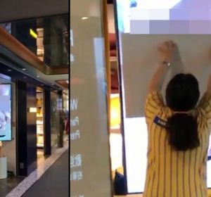 Una dependienta trata de tapar la pantalla de un escaparate de Ikea. Una dependienta trata de tapar la pantalla de un escaparate de Ikea.