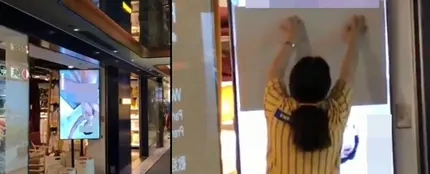 Una dependienta trata de tapar la pantalla de un escaparate de Ikea. Una dependienta trata de tapar la pantalla de un escaparate de Ikea.
