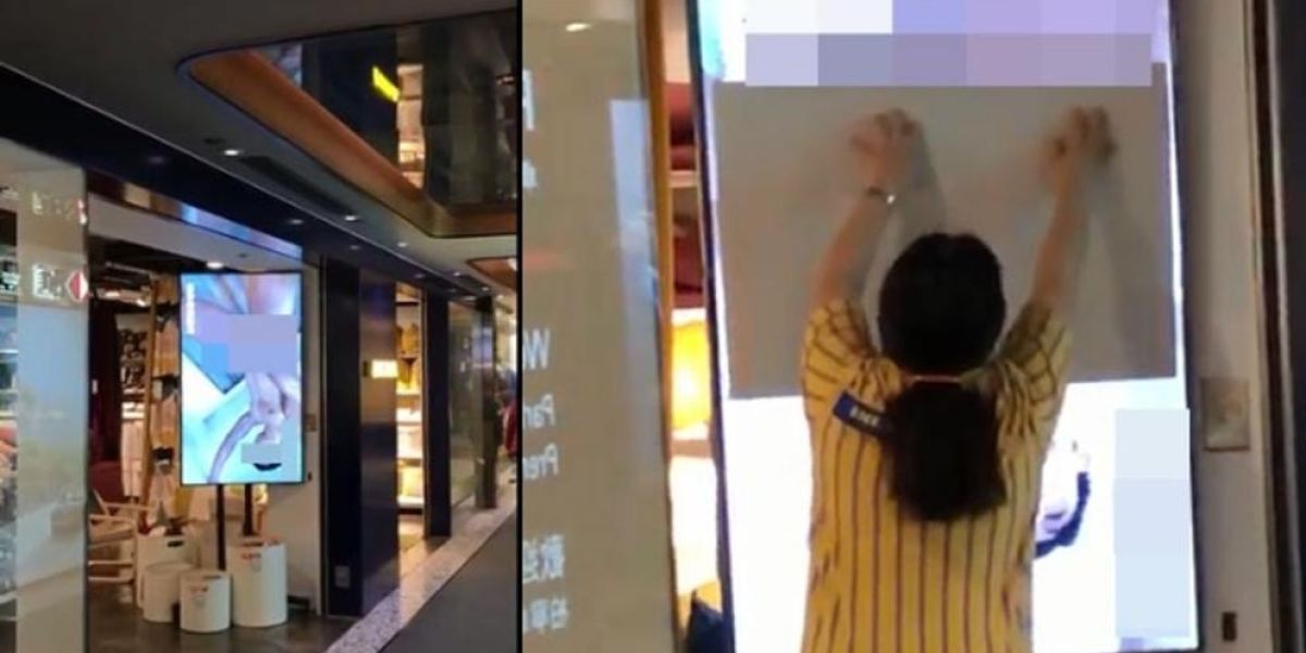 Una dependienta trata de tapar la pantalla de un escaparate de Ikea.