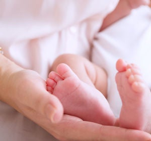 Una madre sosteniendo los pies de su bebé Una madre sosteniendo los pies de su bebé