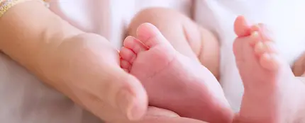 Una madre sosteniendo los pies de su bebé Una madre sosteniendo los pies de su bebé