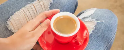 Chica con jeans tomándose un café Chica con jeans tomándose un café