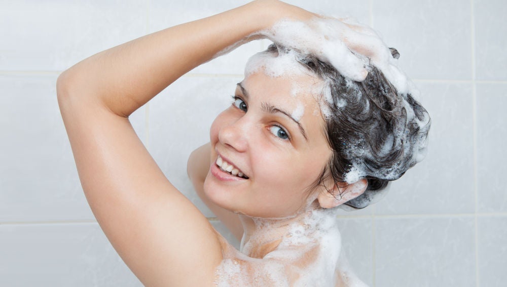 Una chica lavándose el pelo