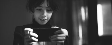 Una ni&ntilde;a jugando con el m&oacute;vil