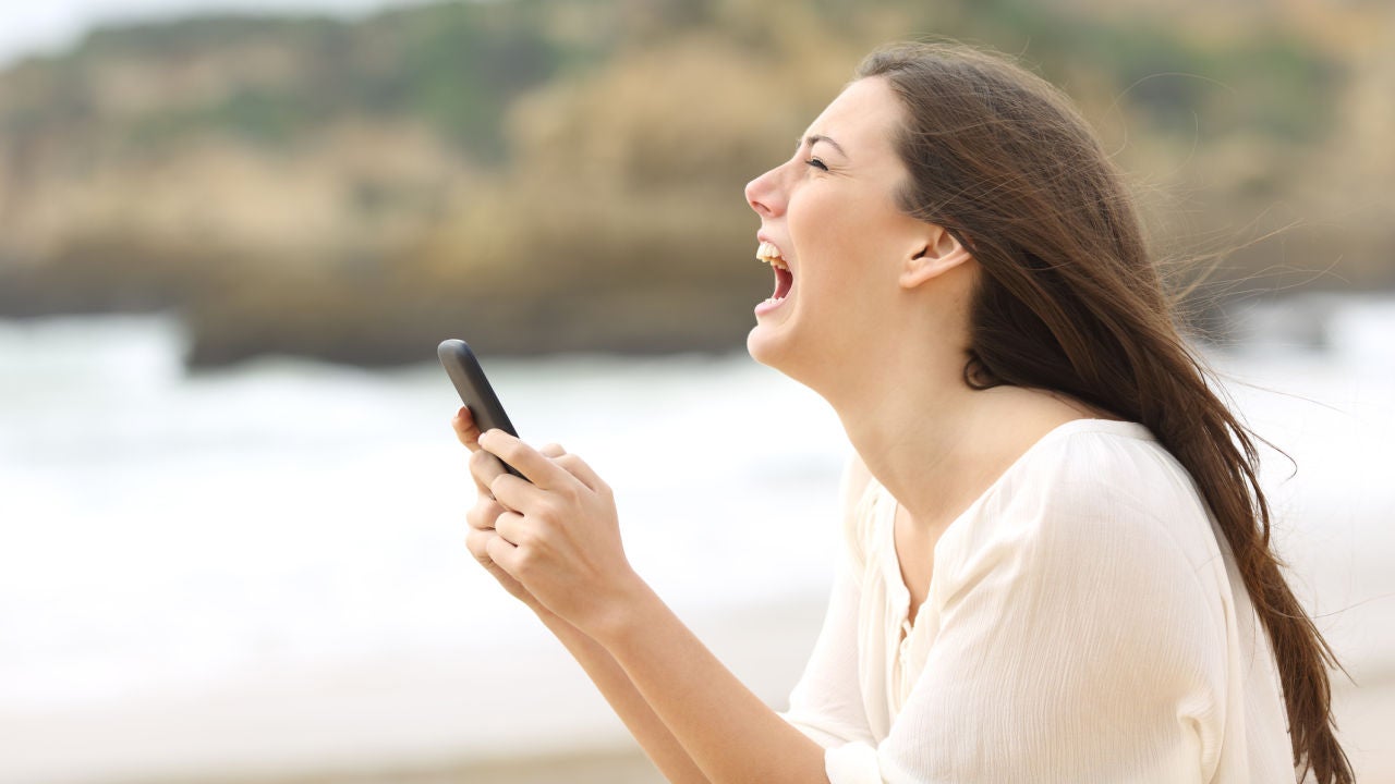 Joven enfadada que mira su teléfono móvil