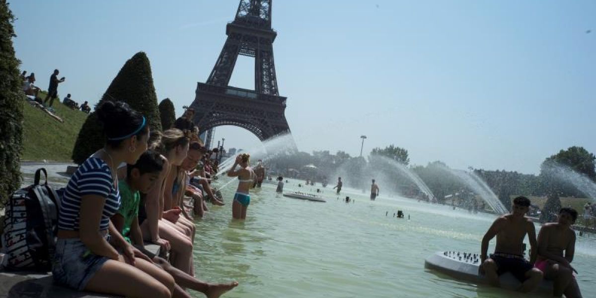 Ciudadanos franceses combaten el calor frente a la Torre Eiffel