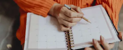 Imagen de archivo de una chica apuntando notas en el calendario de una agenda. Imagen de archivo de una chica apuntando notas en el calendario de una agenda.