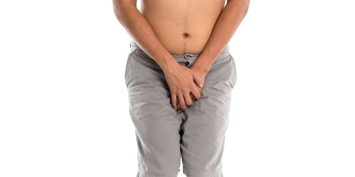 Un hombre agarrándose la entrepierna