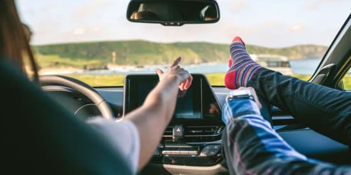 Pies en el salpicadero de un coche