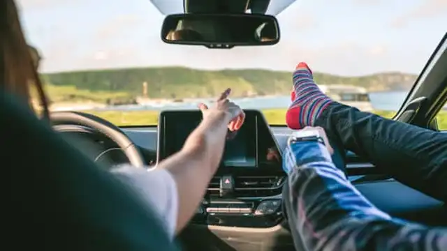 Pies en el salpicadero de un coche