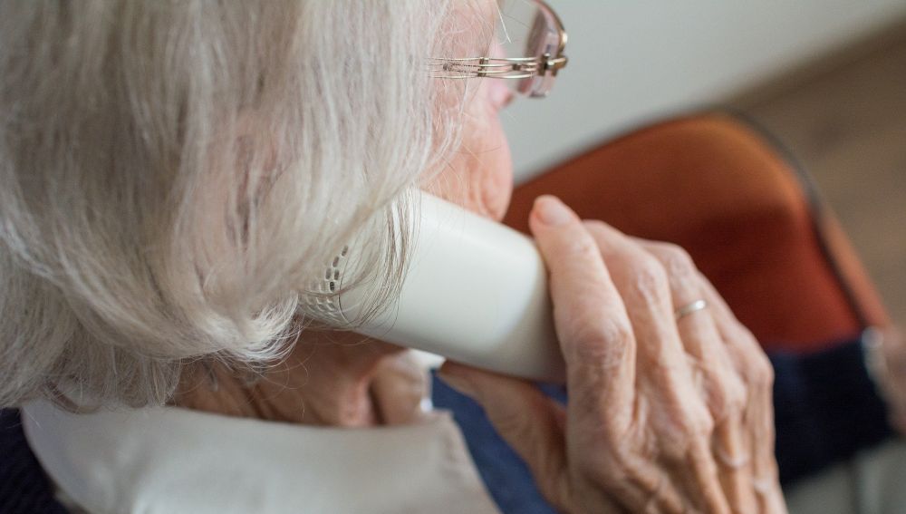 Una anciana hablando por teléfono