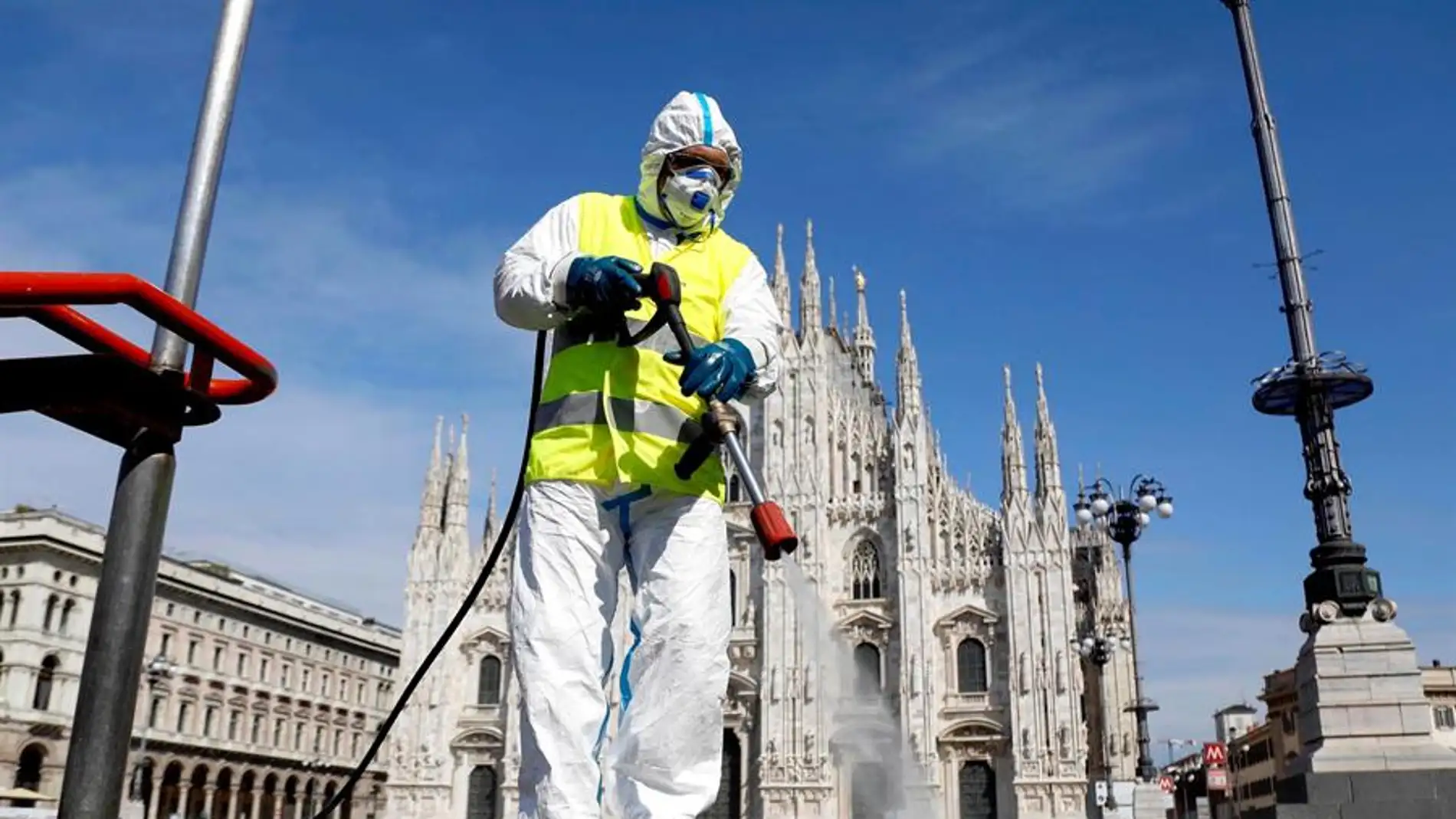Imagen de una persona limpiando las calles en Italia con una mascarilla title=