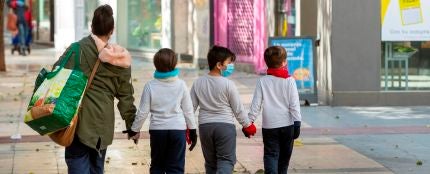 Tres niños acompañan a su madre a hacer la compra en Zaragoza