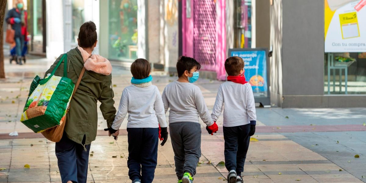 Tres niños acompañan a su madre a hacer la compra en Zaragoza
