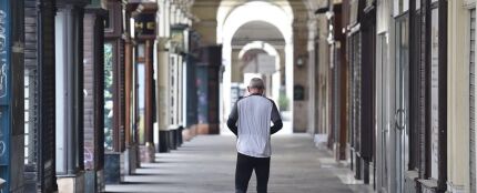 Un hombre camina por una calle vacía de Turín.